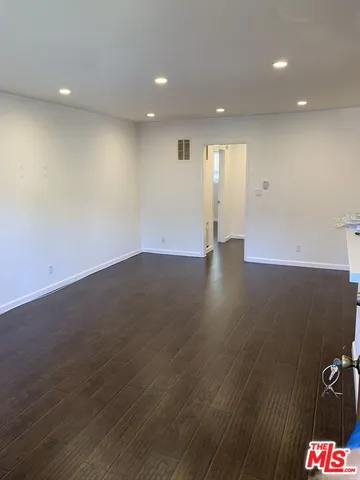 an empty room with wooden floor and natural light