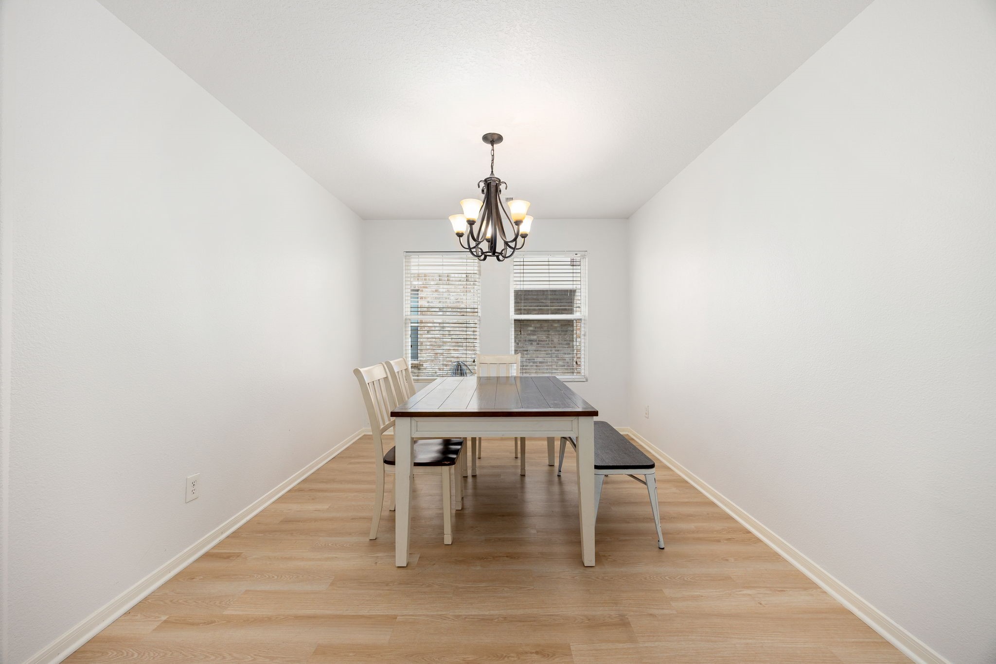 5038 Natchez Ridge Court Katy, TX 77449 - Photo 12 of 26 a dining room with wooden floor a chandelier a wooden table and chairs