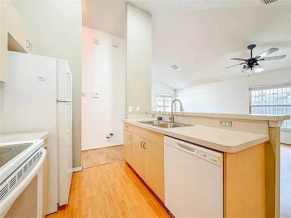 a large white kitchen with a sink a stove and a refrigerator
