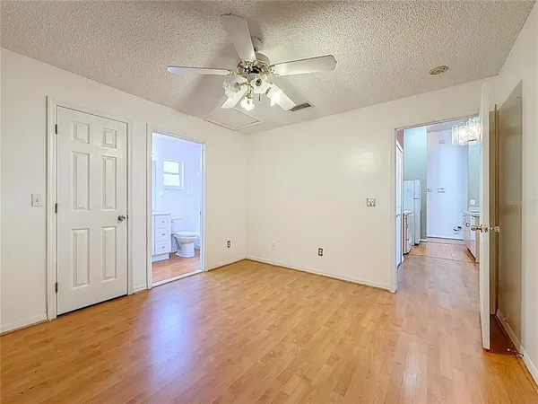 an empty room with closet and a chandelier fan