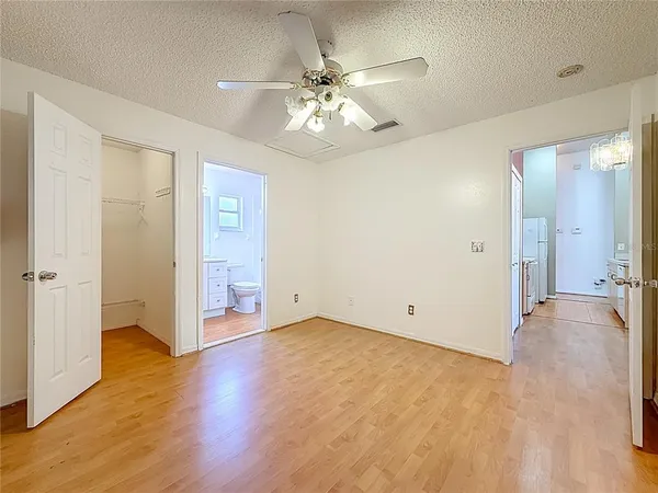 an empty room with a ceiling fan and a window