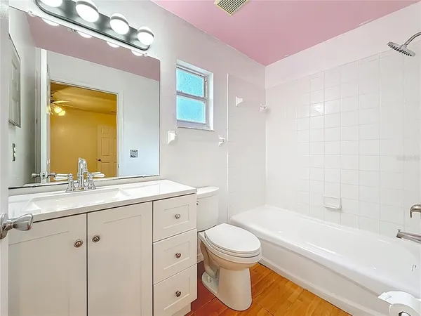 an empty room with chandelier fan and windows