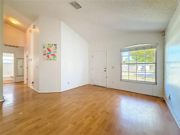 a view of a livingroom with a ceiling fan and kitchen view