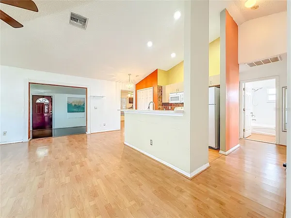 a view of a kitchen with a stove cabinets a ceiling fan and wooden floor