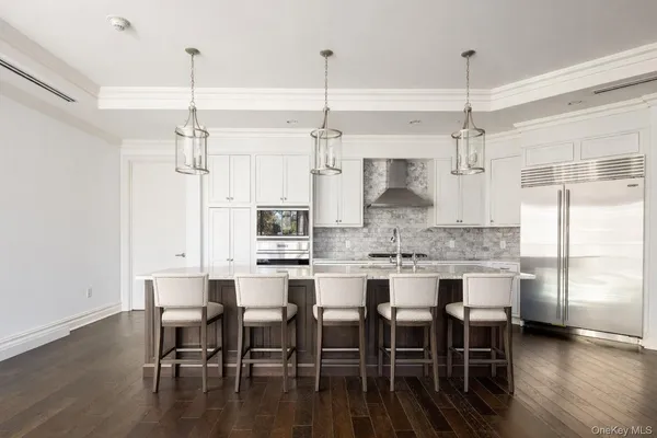 a kitchen with kitchen island a dining table chairs and wooden floor