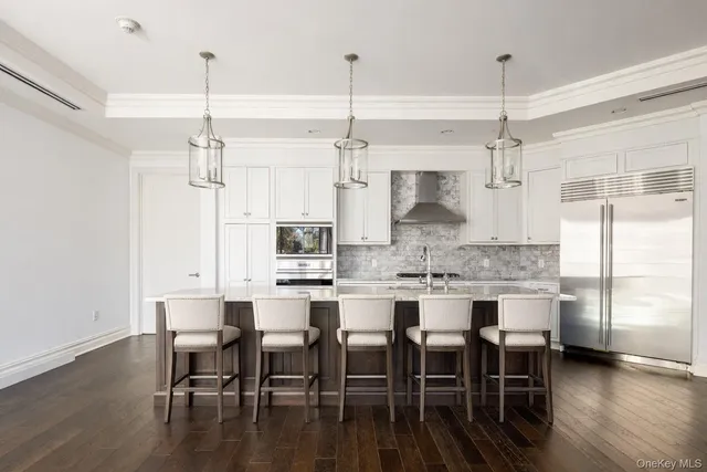 a kitchen with kitchen island a dining table chairs and wooden floor