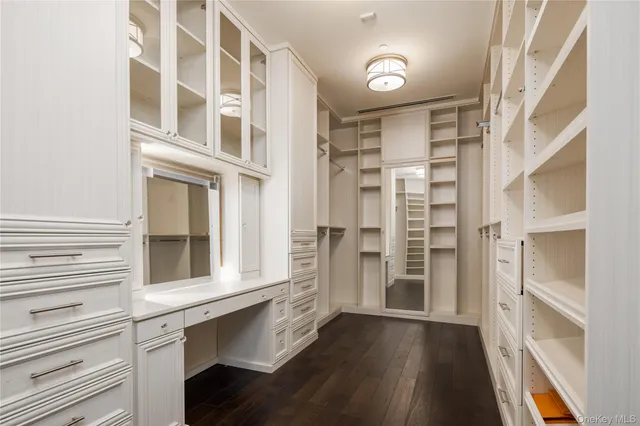 a view of walk in closet with wooden floor and cabinet