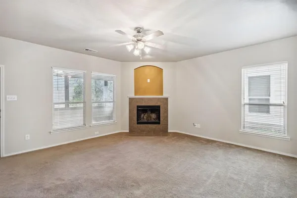 a view of an empty room with a fireplace and a window