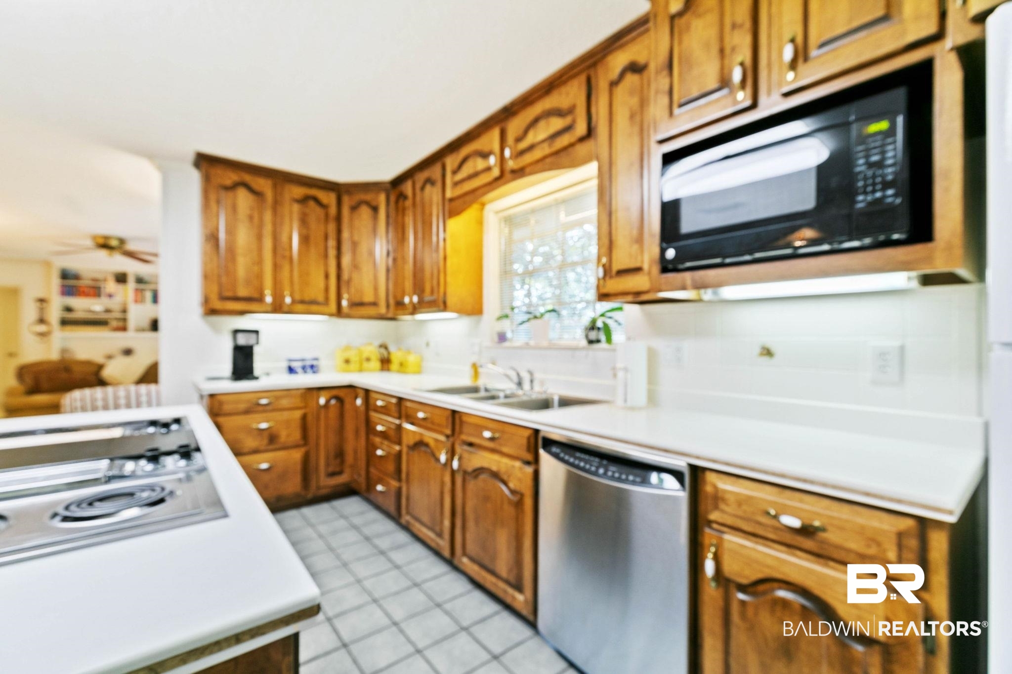 752 Evergreen Street Fairhope, AL 36532 - Photo 11 of 100 Kitchen featuring light countertops, appliances with stainless steel finishes, brown cabinets, a ceiling fan, and light tile patterned floors