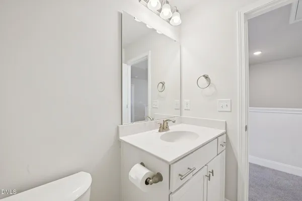 a bathroom with a sink a toilet and a mirror