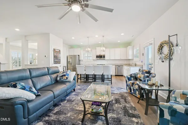 a living room with furniture kitchen view and a chandelier