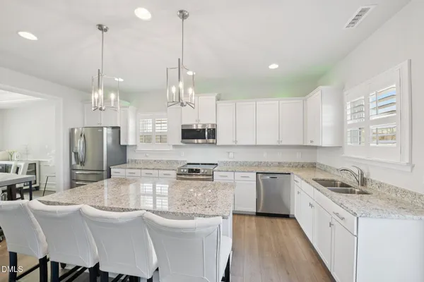 a kitchen with stainless steel appliances kitchen island granite countertop a sink and cabinets