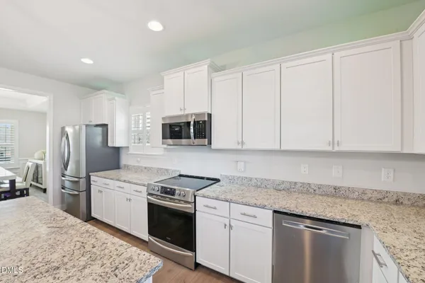 a kitchen with stainless steel appliances granite countertop a stove a sink and a refrigerator