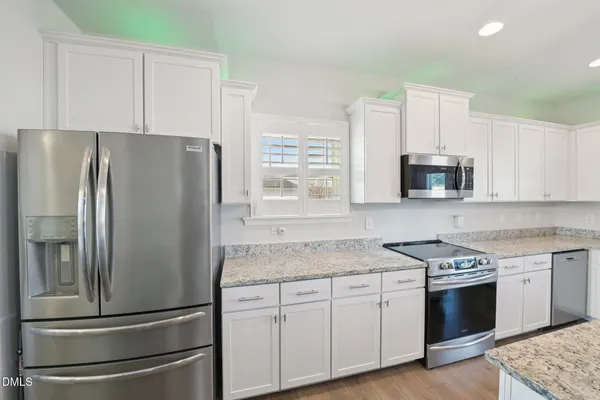 a kitchen with stainless steel appliances granite countertop a refrigerator sink and stove