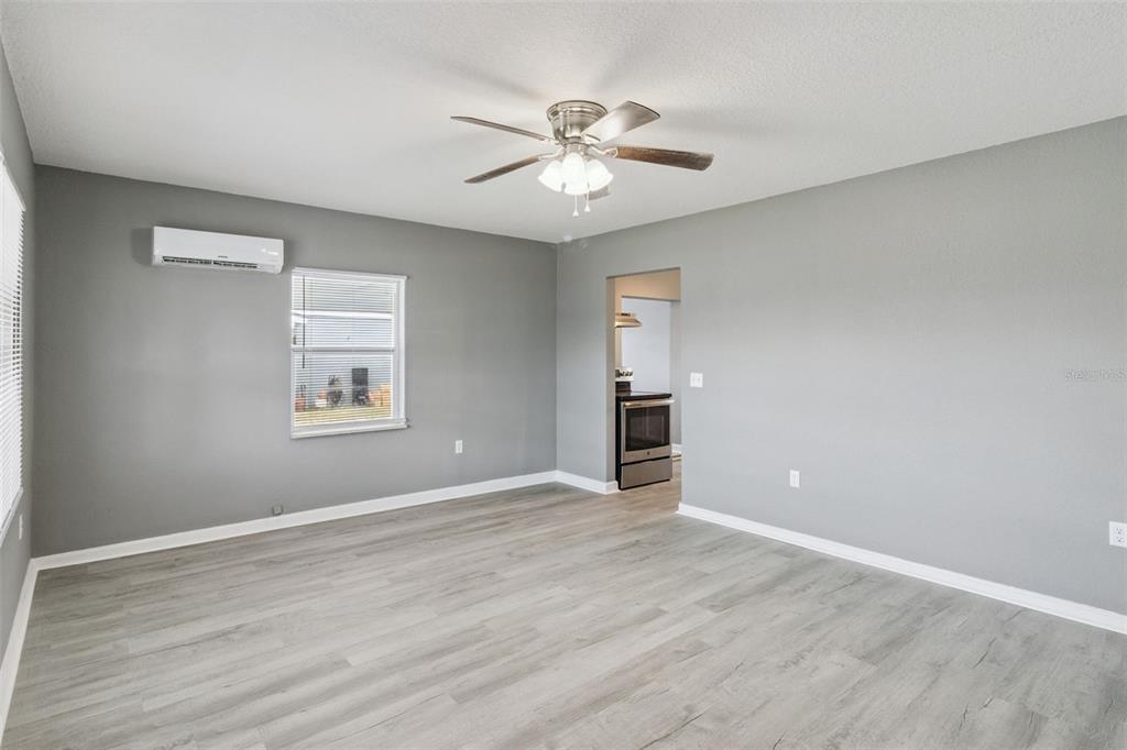 331 Walter Avenue Frostproof, FL 33843 - Photo 5 of 21 wooden floor in an empty room with a window
