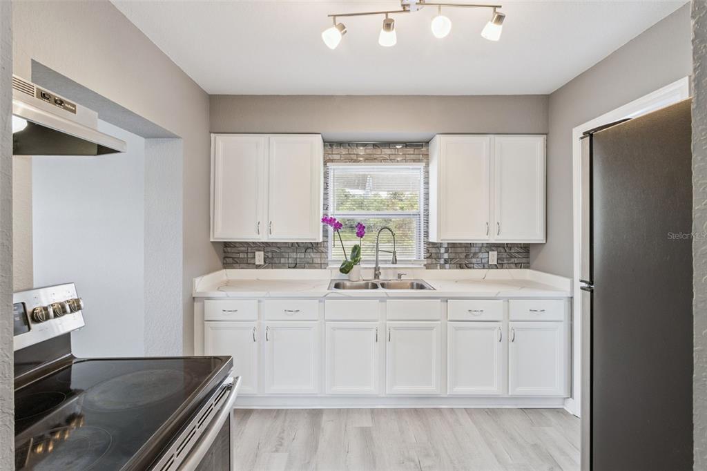 331 Walter Avenue Frostproof, FL 33843 - Photo 6 of 21 a kitchen with a sink stove and cabinets