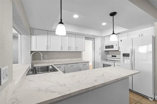 a kitchen with stainless steel appliances a refrigerator sink and microwave