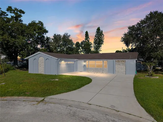 a front view of a house with a yard and trees