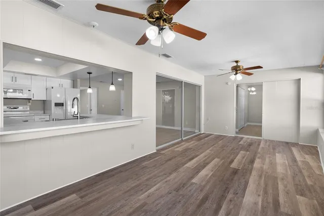 a view of an empty room and kitchen view