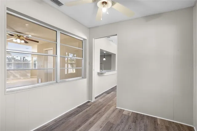 a view of a hallway with wooden floor and a window