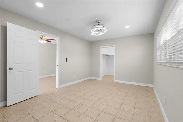 an empty room with windows and closet