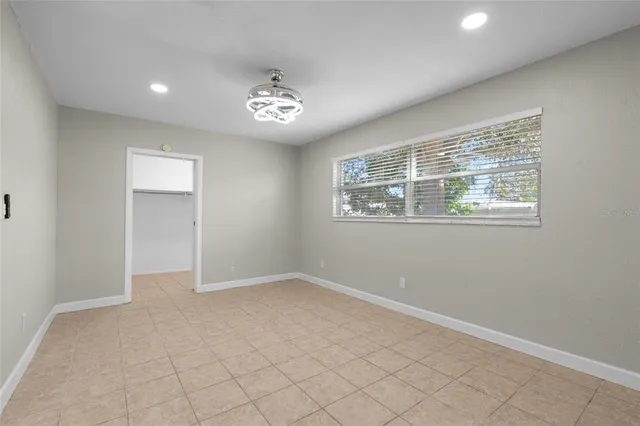 en empty room with windows and ceiling fan