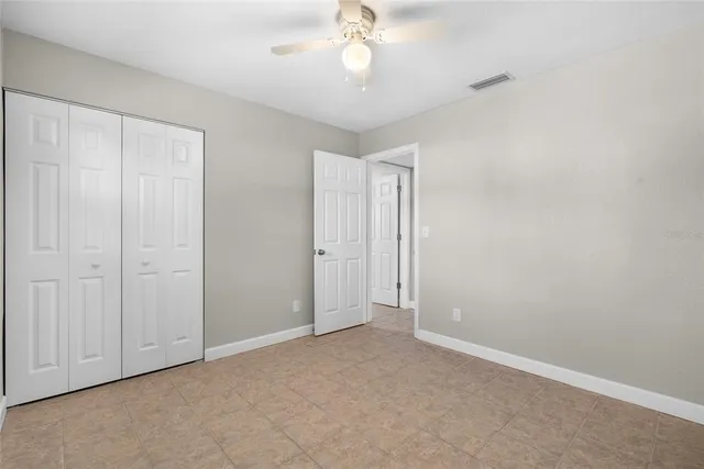 an empty room with a chandelier fan