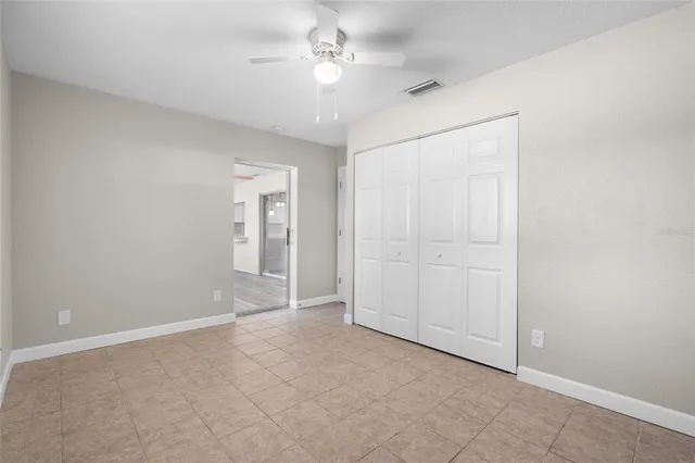 an empty room with fan and entrance