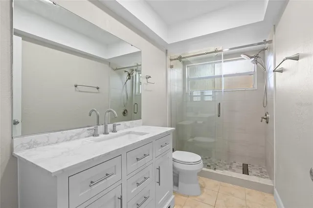 a bathroom with a shower sink vanity mirror and toilet