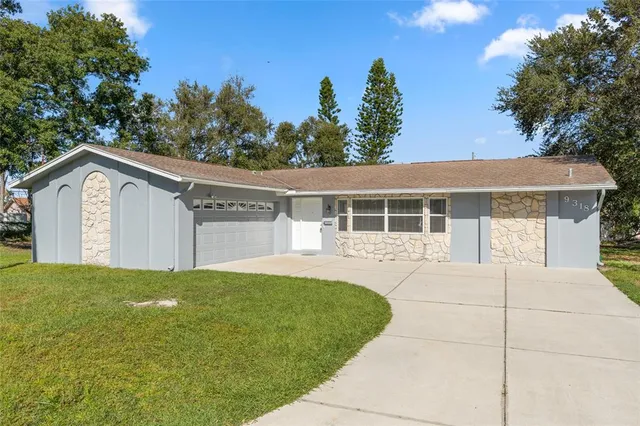 a view of a house with a yard and potted plants