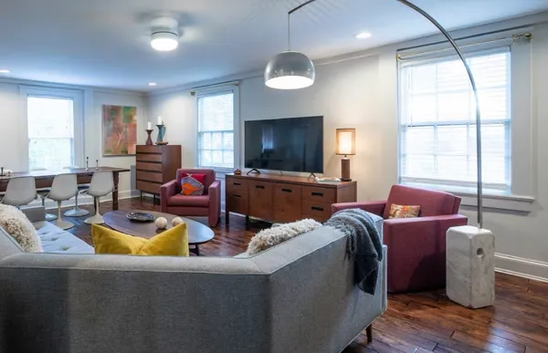 a dining room with wooden floor a glass table and chairs