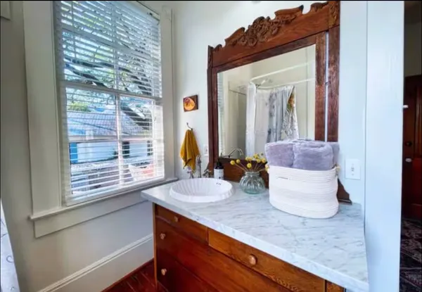 a bathroom with a granite countertop sink a toilet and shower