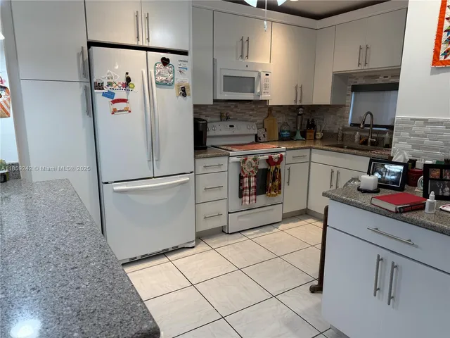 a kitchen with stainless steel appliances a refrigerator sink and cabinets