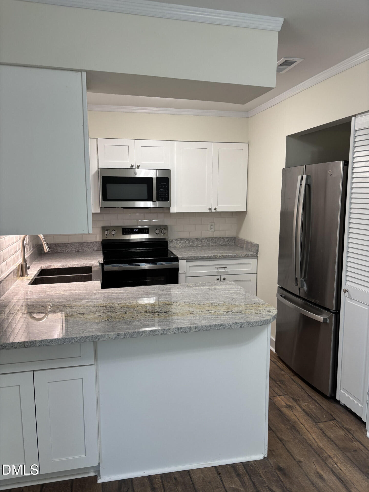 5612 Falls Of Neuse Road, Unit D Raleigh, NC 27609 - Photo 2 of 14 a kitchen with granite countertop a refrigerator and a stove top oven