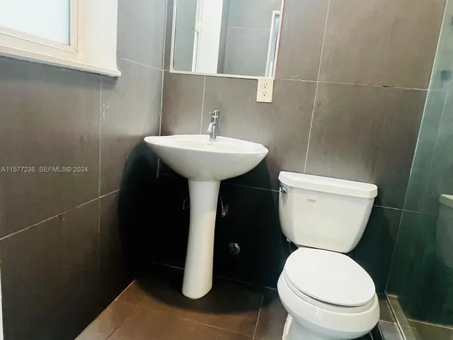 a bathroom with a sink toilet and a mirror