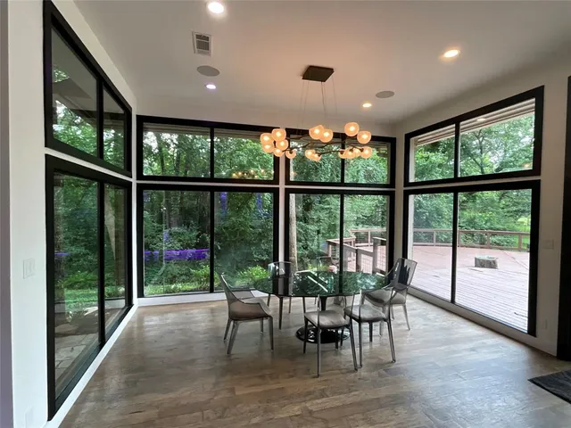 a view of a dining room with furniture large windows and wooden floor