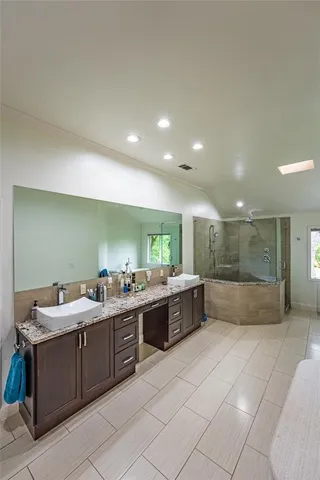 a large white kitchen with a large counter top and stainless steel appliances