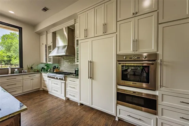 a kitchen with stainless steel appliances a stove a refrigerator and cabinets