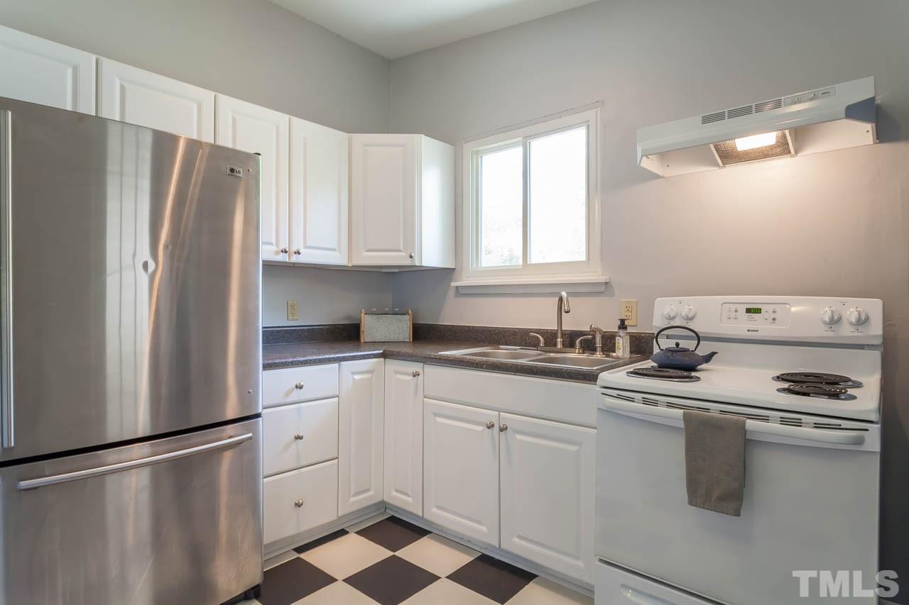 859 Hadley Road Raleigh, NC 27610 - Photo 4 of 17 The bright kitchen has ceramic tile floors and clean white cabinets.