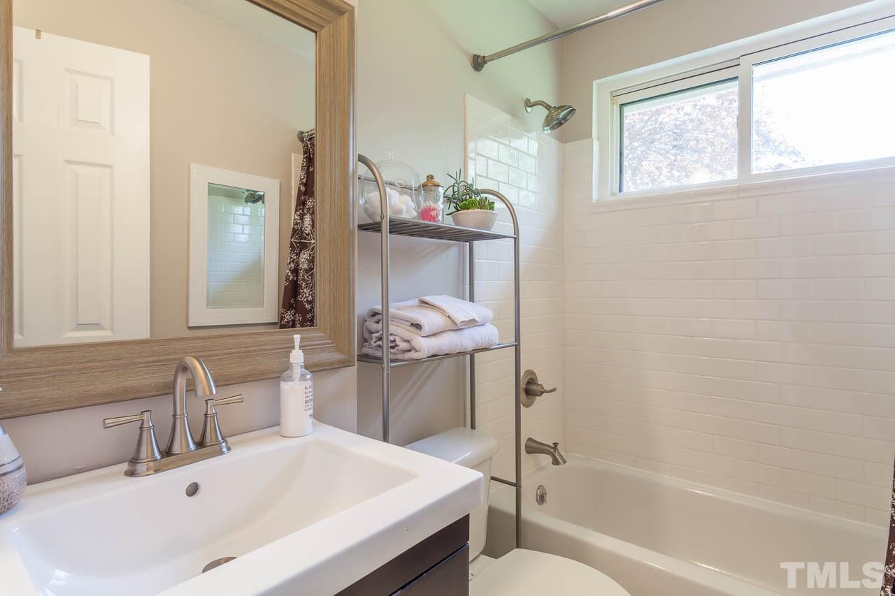 859 Hadley Road Raleigh, NC 27610 - Photo 8 of 17 The bathroom has new subway tile surround in the bath/shower, and new black and white hex tile floor.