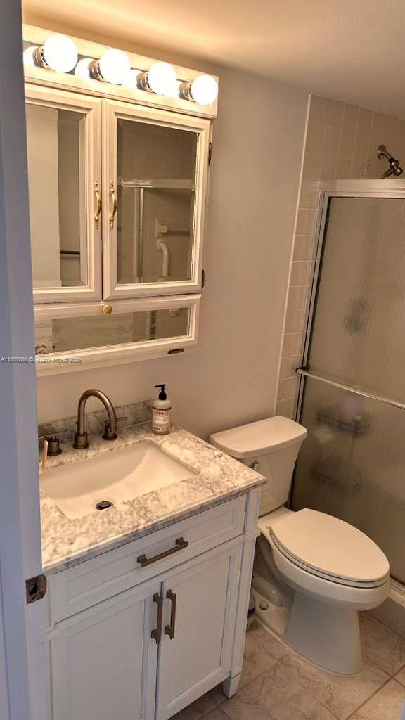 4050 Ainslie Drive, Unit 4050 Boca Raton, FL 33434 - Photo 12 of 17 a bathroom with a granite countertop toilet sink and mirror