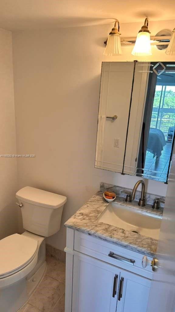 4050 Ainslie Drive, Unit 4050 Boca Raton, FL 33434 - Photo 14 of 17 a bathroom with a toilet sink and mirror