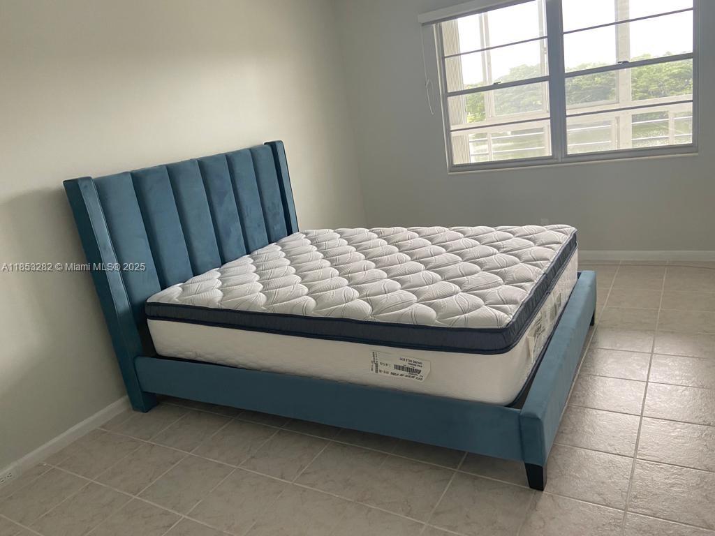 4050 Ainslie Drive, Unit 4050 Boca Raton, FL 33434 - Photo 16 of 17 a bed sitting in a bedroom next to a window