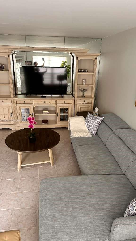 4050 Ainslie Drive, Unit 4050 Boca Raton, FL 33434 - Photo 2 of 17 a living room with furniture and a flat screen tv