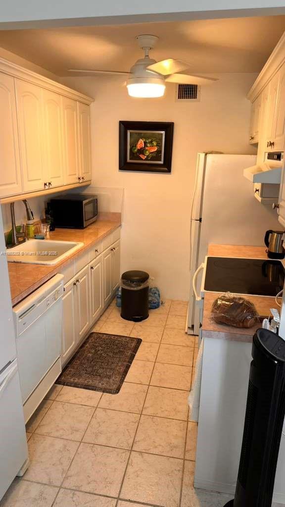 4050 Ainslie Drive, Unit 4050 Boca Raton, FL 33434 - Photo 8 of 17 a kitchen with a sink appliances and cabinets