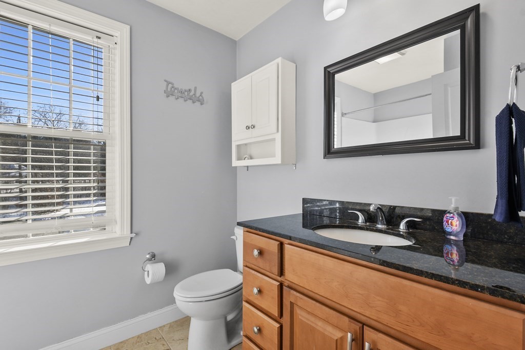 211 Barre Paxton Road, Unit 2 Rutland, MA 01543 - Photo 18 of 30 a bathroom with a granite countertop sink a toilet and a mirror