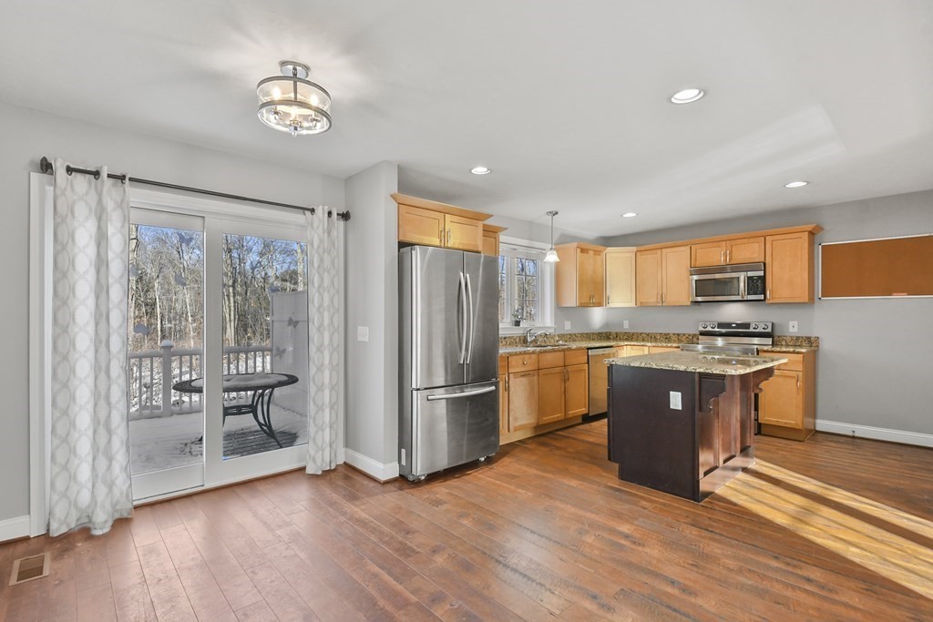 211 Barre Paxton Road, Unit 2 Rutland, MA 01543 - Photo 8 of 30 a large kitchen with stainless steel appliances granite countertop a refrigerator and a stove top oven