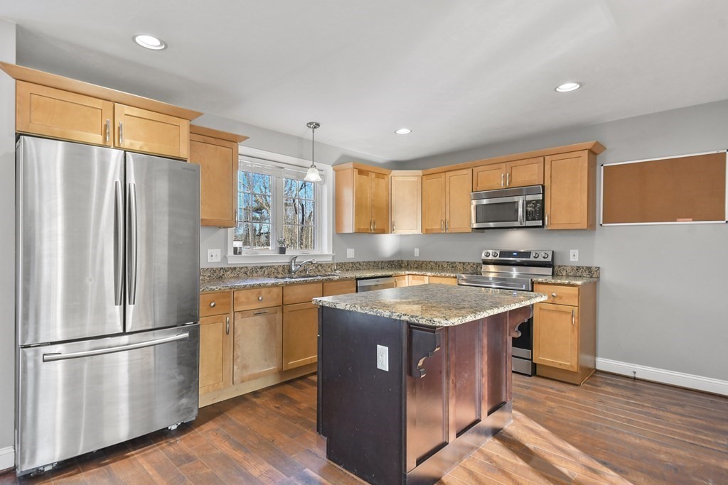 211 Barre Paxton Road, Unit 2 Rutland, MA 01543 - Photo 9 of 30 a kitchen with stainless steel appliances granite countertop a refrigerator a sink dishwasher a stove and white countertops with wooden floor