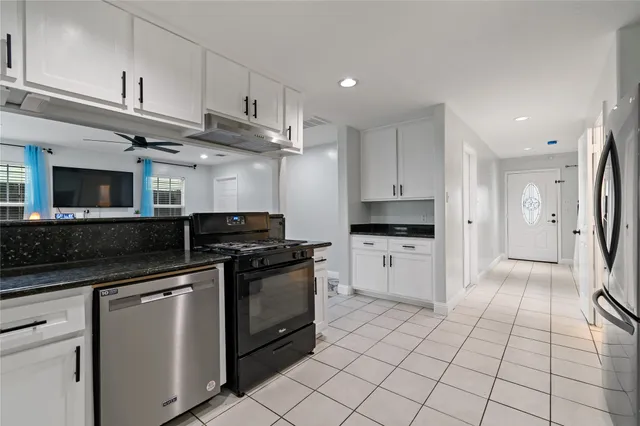 a kitchen with stainless steel appliances granite countertop a stove a sink and a refrigerator