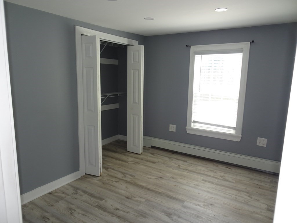 416 Crescent Avenue Chelsea, MA 02150 - Photo 12 of 21 an empty room with wooden floor and windows